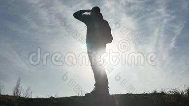 <strong>剪影</strong>阳光游客徒步旅行者背着背包从山顶欣赏日落景色。 徒步旅行者的<strong>剪影</strong>